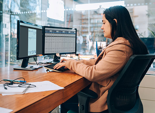 Woman working at a computer in dealership using accounting electronic communications