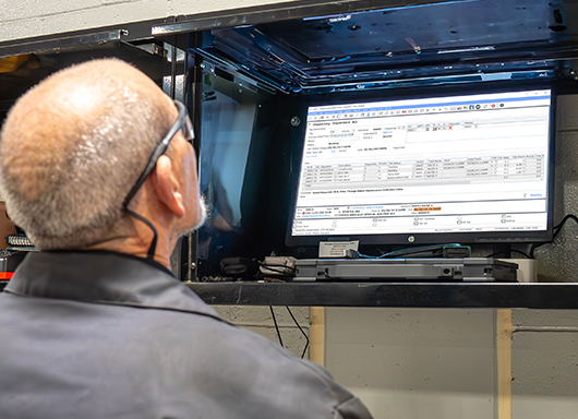 Dispatcher assigning repair orders to technicians via computer