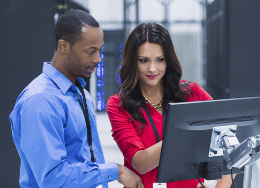 Man and woman in a dealership working together on a computer screen.
